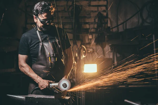 Człowiek za pomocą szlifierki kątowej w fabryce i wyrzucanie iskier — Zdjęcie stockowe