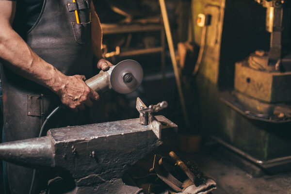 man Using Angle Grinder in Factory and throwing sparks