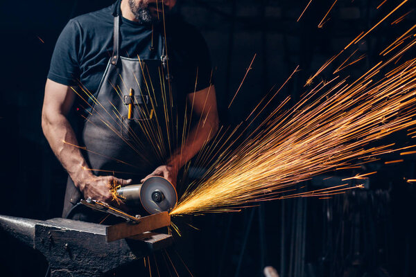 man Using Angle Grinder in Factory and throwing sparks