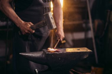 el ile smithy atölye örs üzerinde erimiş metal dövme demirci
