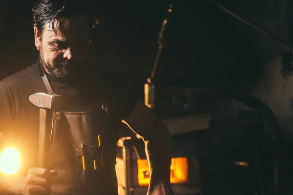 Schmied schmiedet das geschmolzene Metall manuell auf dem Amboss in der Schmiede — Stockfoto