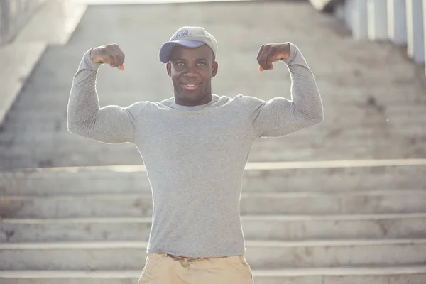 Modelo atlético forte da aptidão do homem que mostra seu bíceps . — Fotografia de Stock