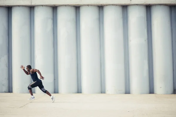 Здоровый молодой спортсмен бежит по дороге — стоковое фото