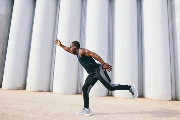 Привабливий чоловік швидко бігає під час заходу сонця, чорний чоловік робить тренування на відкритому повітрі — стокове фото