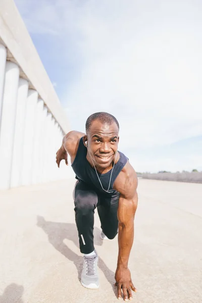 Athletic Man in Running Start Position and Looking Into the Distance at the Park