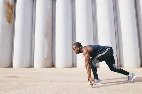 One young african muscular build man on starting pose — Stock Photo, Image