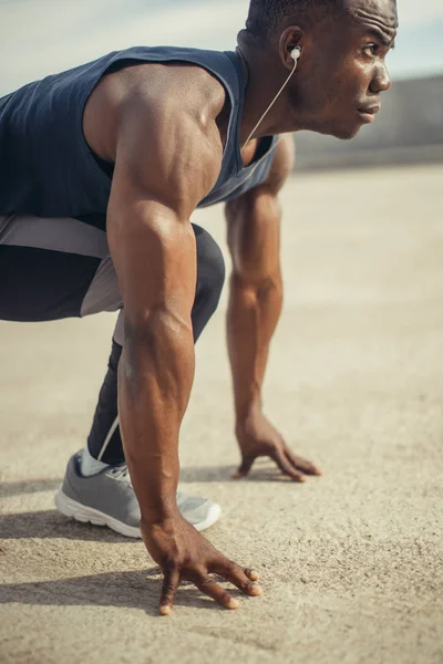 Atletik adam çalışan başlangıç konumu ve mesafe içine parkta arıyor