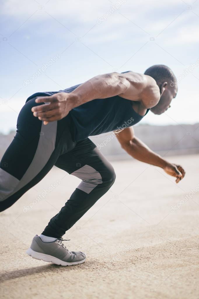 Healthy young athletic man running at the road