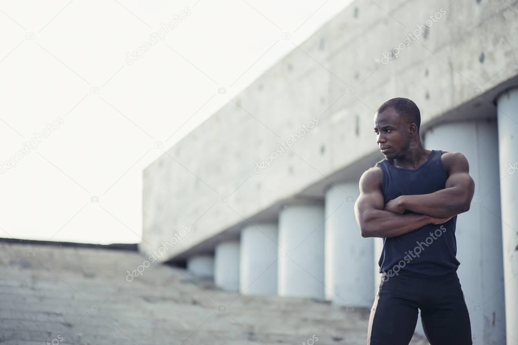 Portrait of attractive African athlete coming home after workout at fitness club