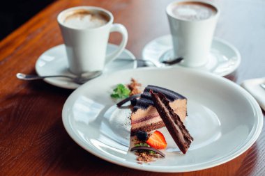 İçiniz rahat katmanlı sufle tatlısı tabakta ahşap masa üzerinde çikolata sos ile