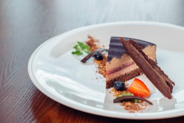 İçiniz rahat katmanlı sufle tatlısı tabakta ahşap masa üzerinde çikolata sos ile