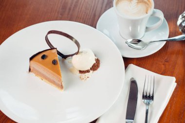 İçiniz rahat katmanlı sufle tatlısı tabakta ahşap masa üzerinde çikolata sos ile