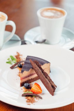 İçiniz rahat katmanlı sufle tatlısı tabakta ahşap masa üzerinde çikolata sos ile