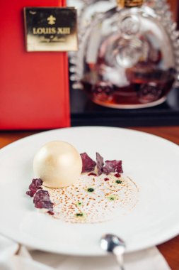 Şekerli tatlı buzlu dondurma topu, şeker şeker, meyve ve nane beyaz plaka üzerinde