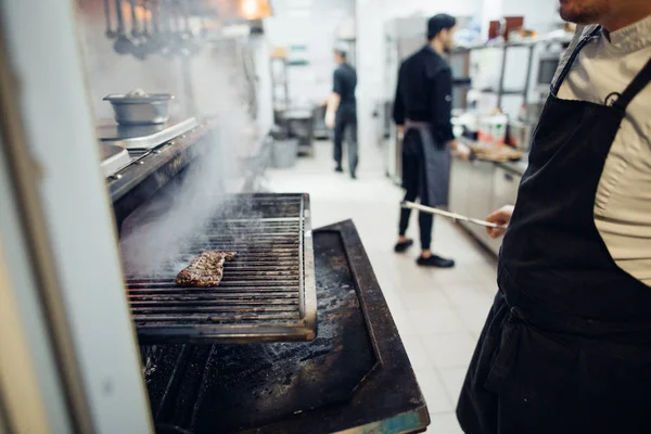 Ízletes marhahús a grillen tűzlángokkal — Stock Fotó