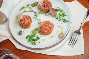 Taş bir plaka üzerinde bir yumurta ile biftek tartar. Kiraz domates. Rosemary. Baharat.