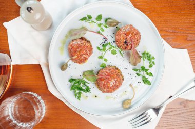 Taş bir plaka üzerinde bir yumurta ile biftek tartar. Kiraz domates. Rosemary. Baharat.