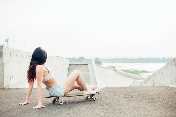 Conceito de estilo de vida - sorrindo jovem mulher ou adolescente sentada no longboard — Fotografia de Stock