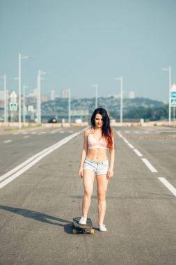 Güzel sexy genç kız kısa şort longboard ile ayakta