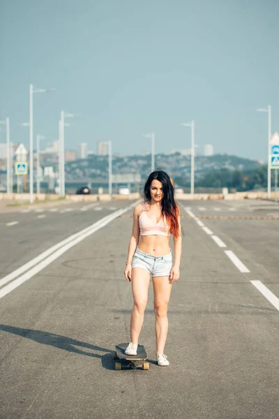 Mooie sexy meisje in korte broek met longboard permanent — Stockfoto