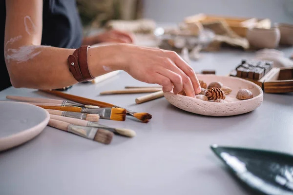 Мастер керамики потирает тарелку с запечённой глиной. Творческая мастерская . — стоковое фото