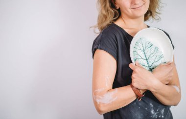 Kadın tezgahı bitmiş çatal bıçaklarla, gülümseyen seramikçi işyeri fırınlanmış fincanlarla