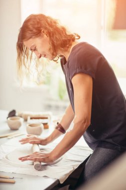 Çömlek atölyesinde merdaneli kadın çömlek kalıbı.