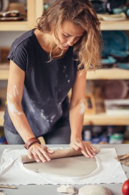 Çömlek atölyesinde merdaneli kadın çömlek kalıbı.