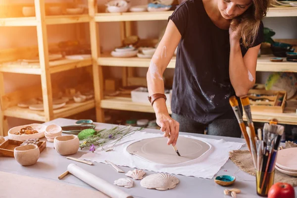 Elleri onun işyerinde kil seramik kesme