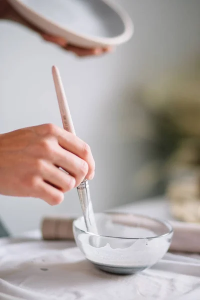 Töpferin bemalt Keramiktasse. Frau arbeitet in ihrem Töpferatelier — Stockfoto