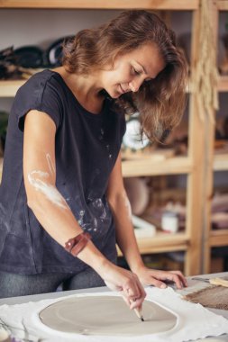 Elleri onun işyerinde kil seramik kesme