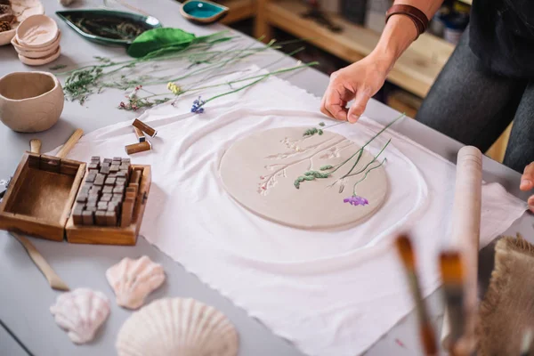 Мастер керамики потирает тарелку с запечённой глиной. Творческая мастерская . — стоковое фото