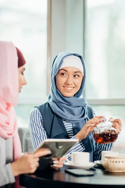 Bella donna musulmana uso tablet in caffè — Foto Stock