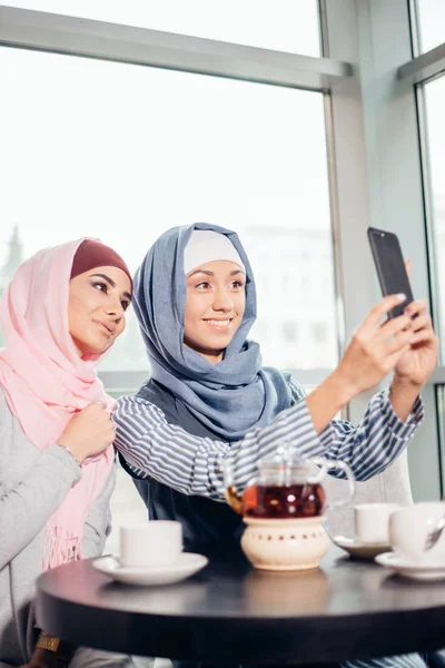 Возбужденные молодые мусульманские девушки подруги делают селфи вместе — стоковое фото