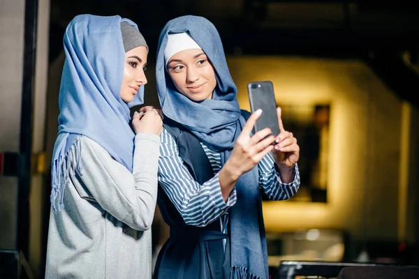 Молодая красивая мусульманка делает автопортрет с камерой телефона — стоковое фото