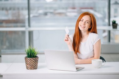 Kadın evde dizüstü bilgisayarıyla alışveriş yapıyor.