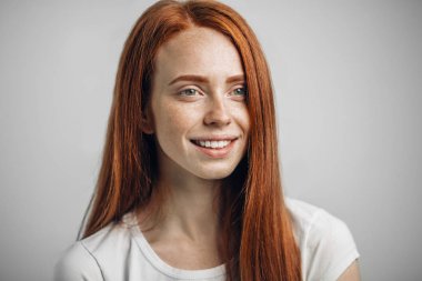 Kameraya bakıp gülümseyen mutlu kızıl kız.