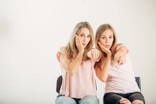 Dos hermanas gemelas atractivas señalando sobre fondo blanco — Foto de Stock