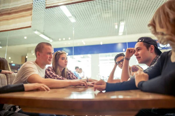 Группа студентов, сидящих в кафе-баре и смотрящих друг на друга — стоковое фото