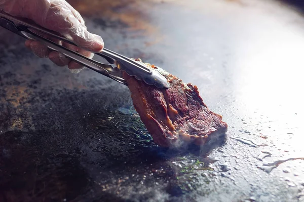 夹持煎肉。厨师正在准备猪肉 — 图库照片