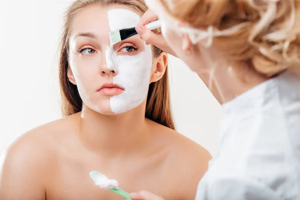 Mujer recibiendo cuidado facial por esteticista en el salón de spa, vista lateral, primer plano —  Fotos de Stock
