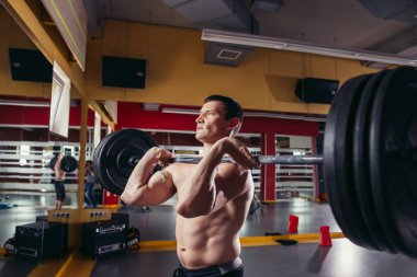 Genç adam barbell deadlift egzersiz sırasında kaldırma