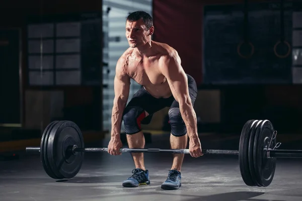 Entrenamiento muscular de hombre con barra en el gimnasio — Foto de Stock