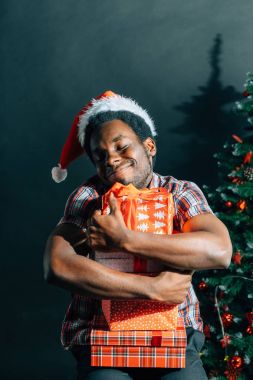 Noel hediyesi elinde tutan çekici gülümseme ile Afro Amerikan adam