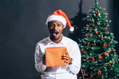 Noel hediyesi elinde tutan çekici gülümseme ile Afro Amerikan adam
