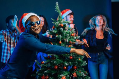 Afrika kökenli Amerikalı adam Noel ağacı ile sarılma