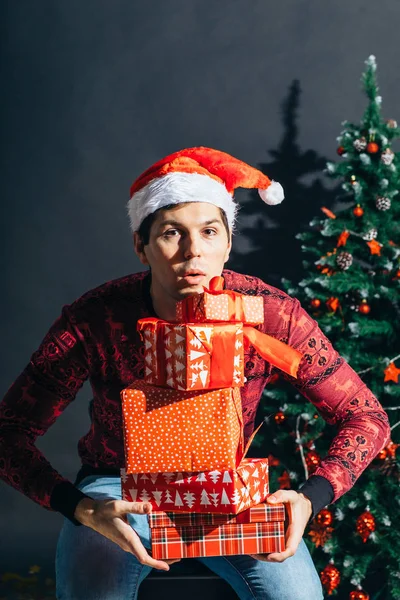 Man Holding Giftbox. Bonito macho com caixa de presente em mãos sobre árvore de Natal — Fotografia de Stock