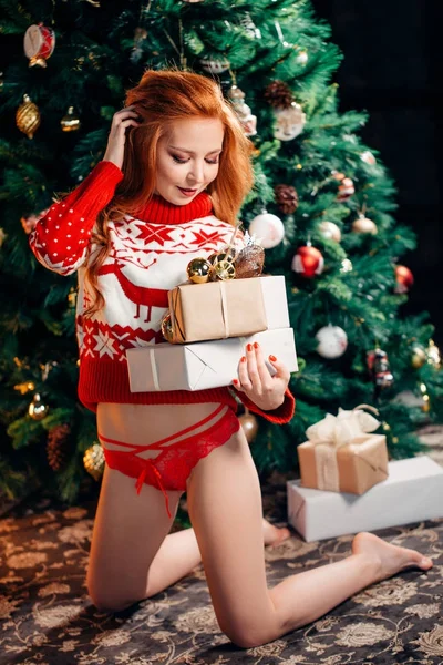 Hermosa mujer sexy en suéter rojo de Navidad. Mujer de invierno con regalo de Navidad —  Fotos de Stock