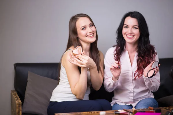 Dos mujeres jóvenes revisando productos de belleza en video blog en casa — Foto de Stock