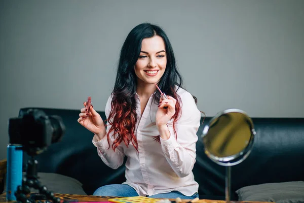 Blogger femenina con cosméticos de maquillaje grabando video en casa — Foto de Stock